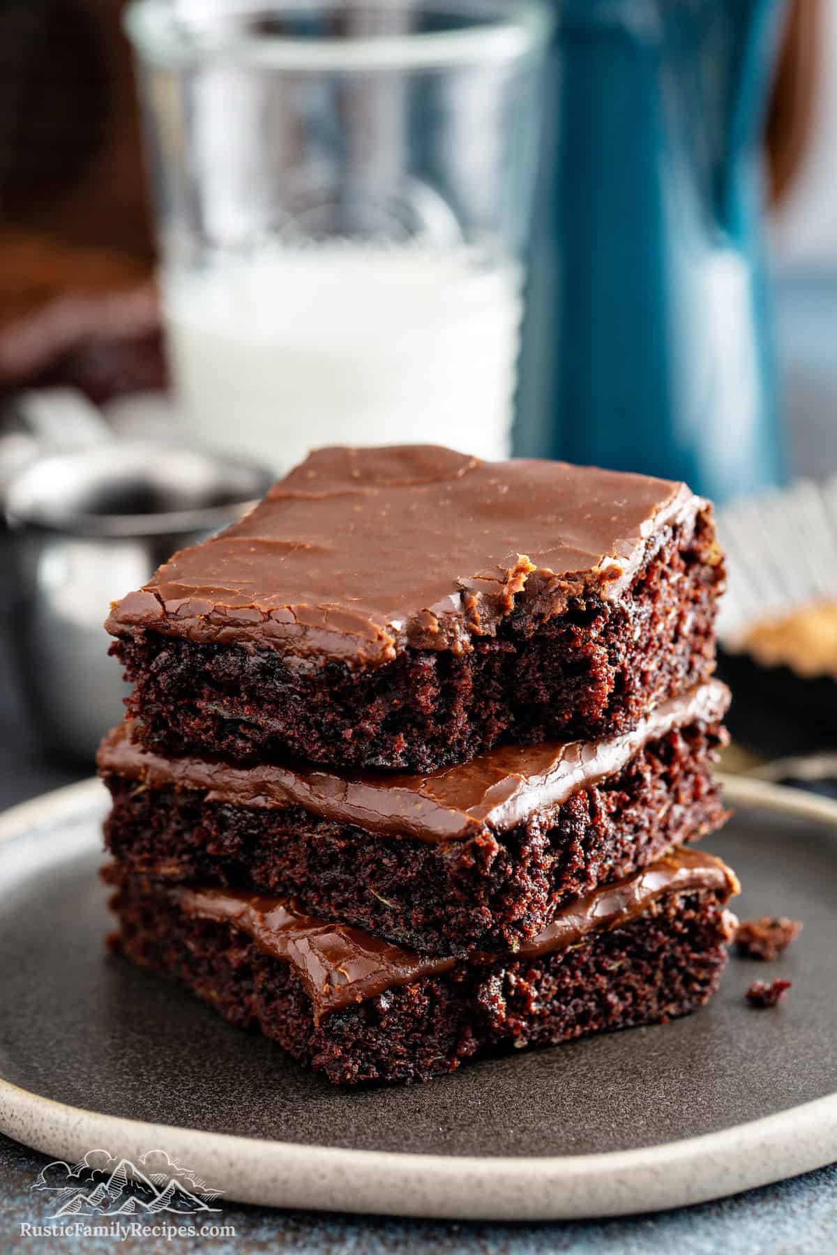 Stack of 3 zucchini brownies with a glass of milk