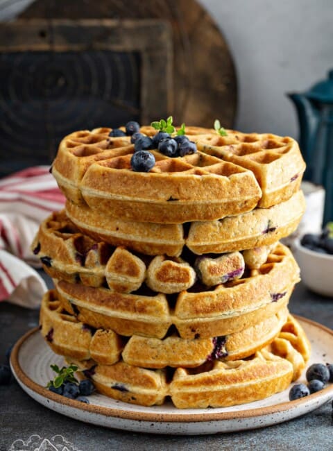 A stack of Blueberry Buttermilk Waffles on a plate.