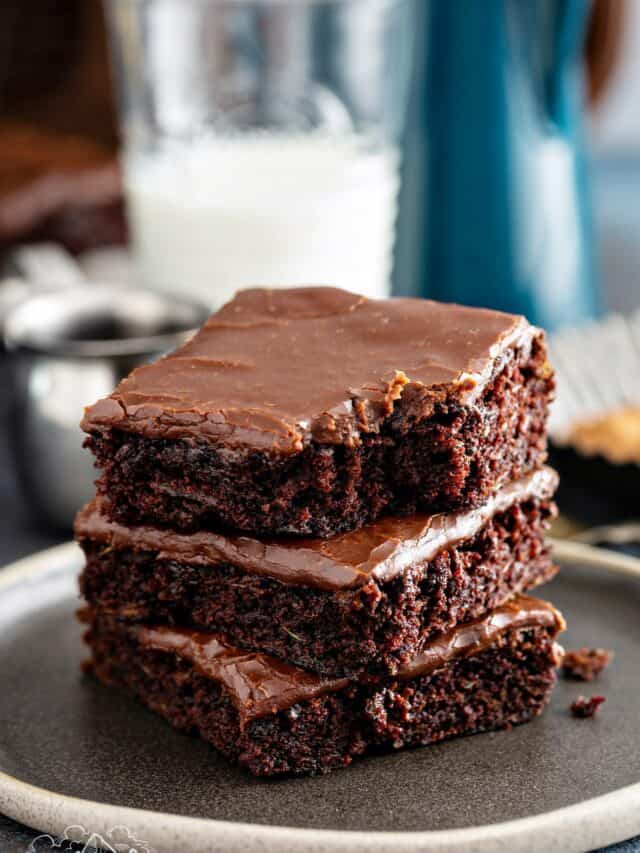 Stack of 3 zucchini brownies with a glass of milk