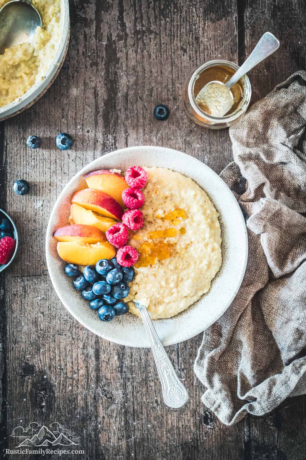 A bowl of millet porridge topped with fresh fruit, cinnamon sugar, and maple syrup.