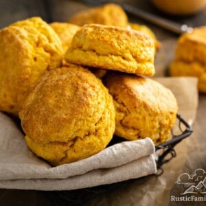 Sweet Potato Biscuits piled in basket, next to a cup of coffee