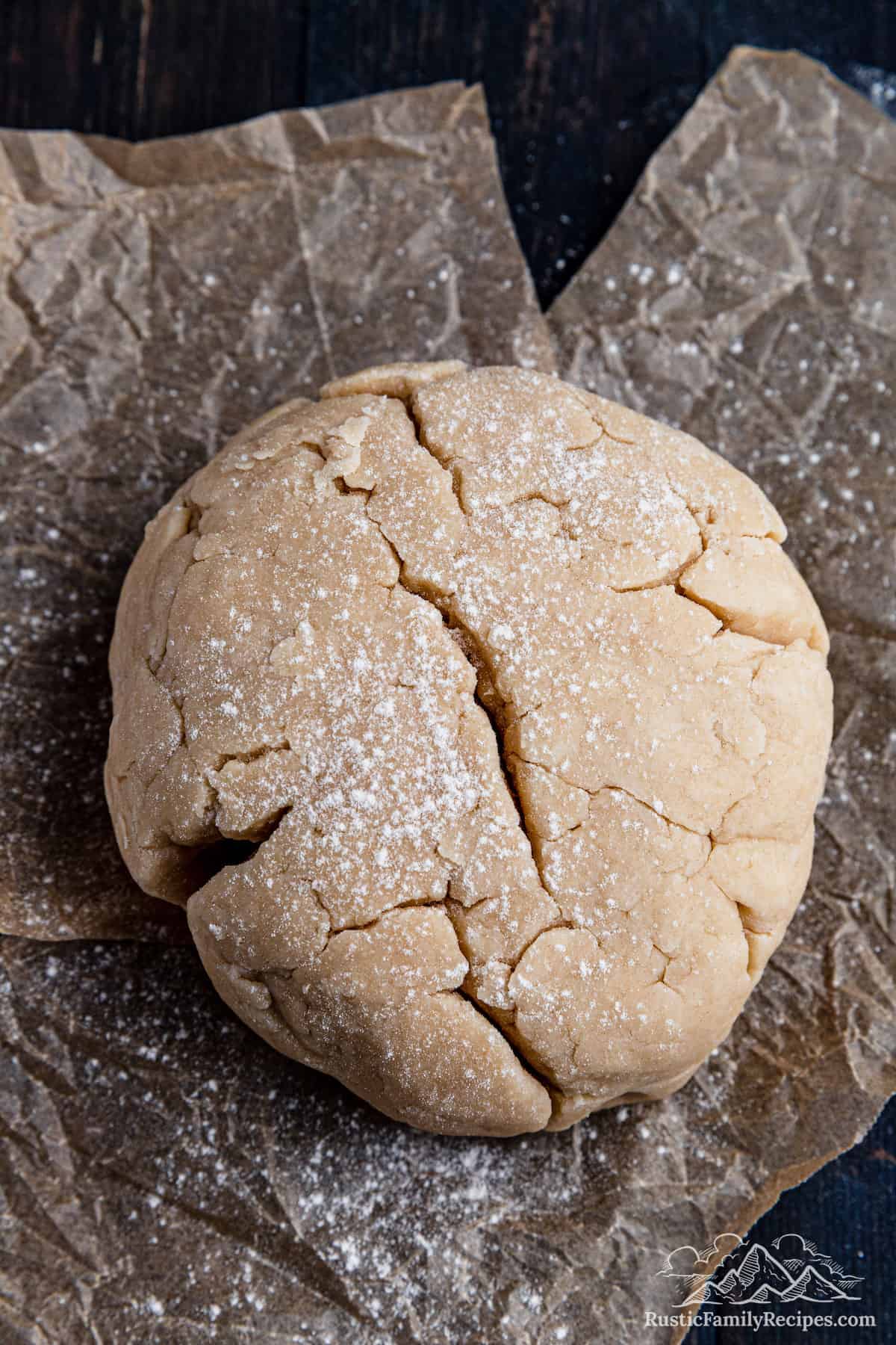 Closeup photo of pie dough rolled into a ball and dusted with flour