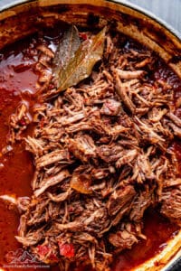 Shredded birria taco meat in broth