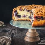 Black currant cake on a stand with slices taken out