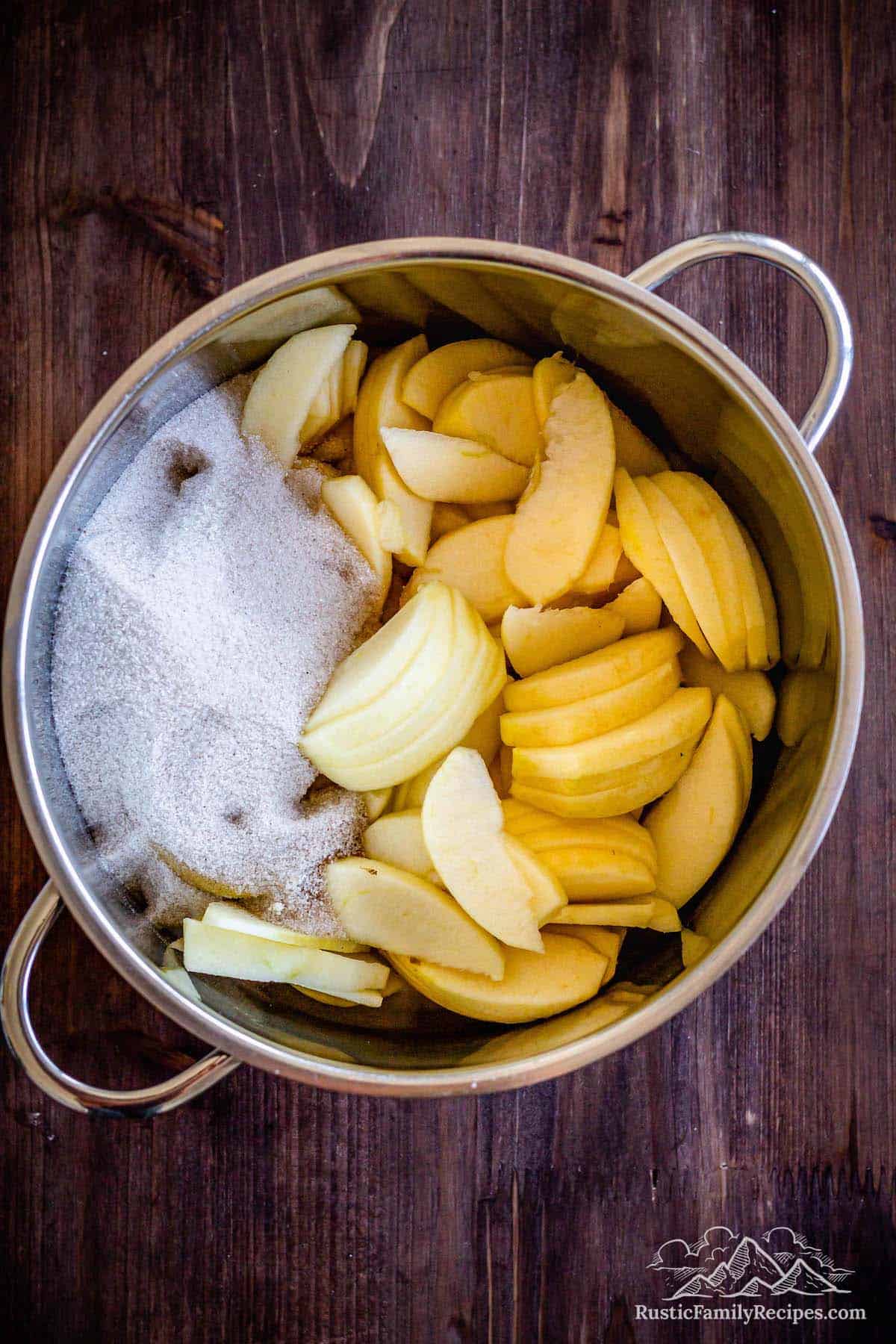 Sliced apples in a pot with cinnamon sugar