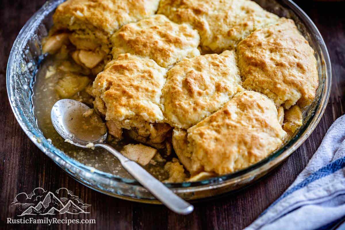 Apple cobbler in a pie pan with a spoon