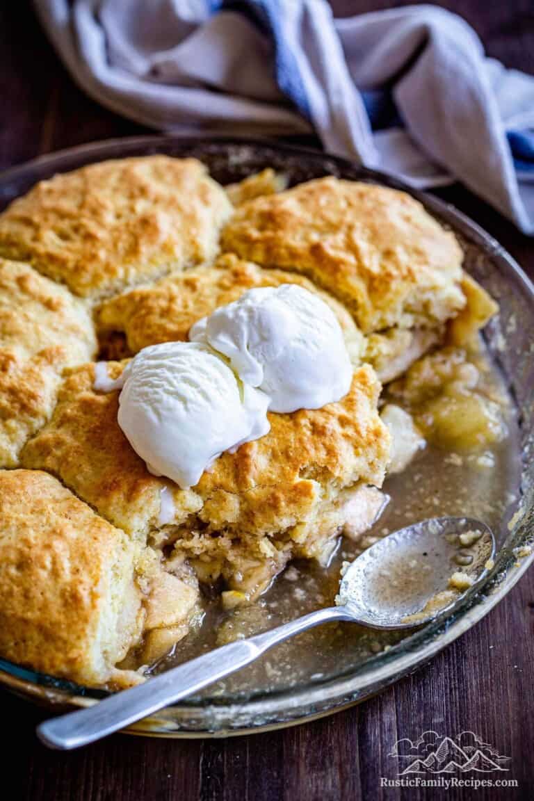 Apple cobbler in a baking dish with ice cream