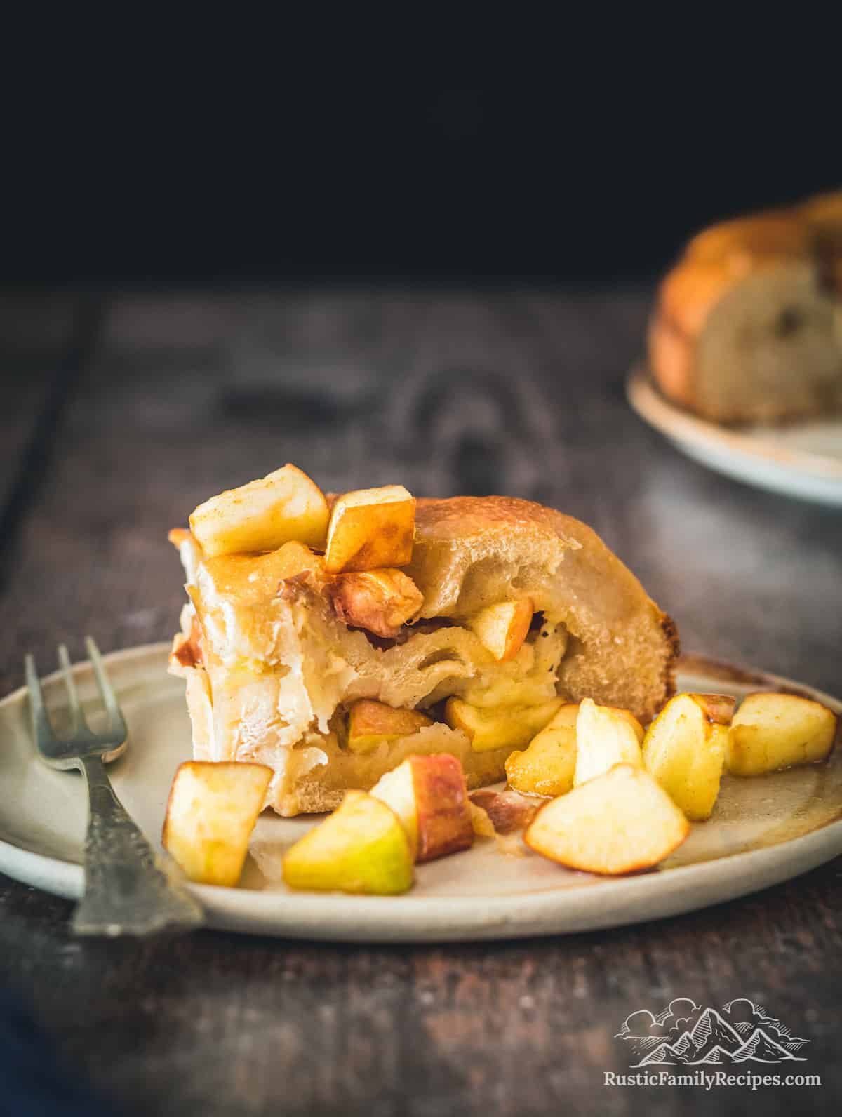 Slice of Apple Harvest Bread on plate with apples scattered around it