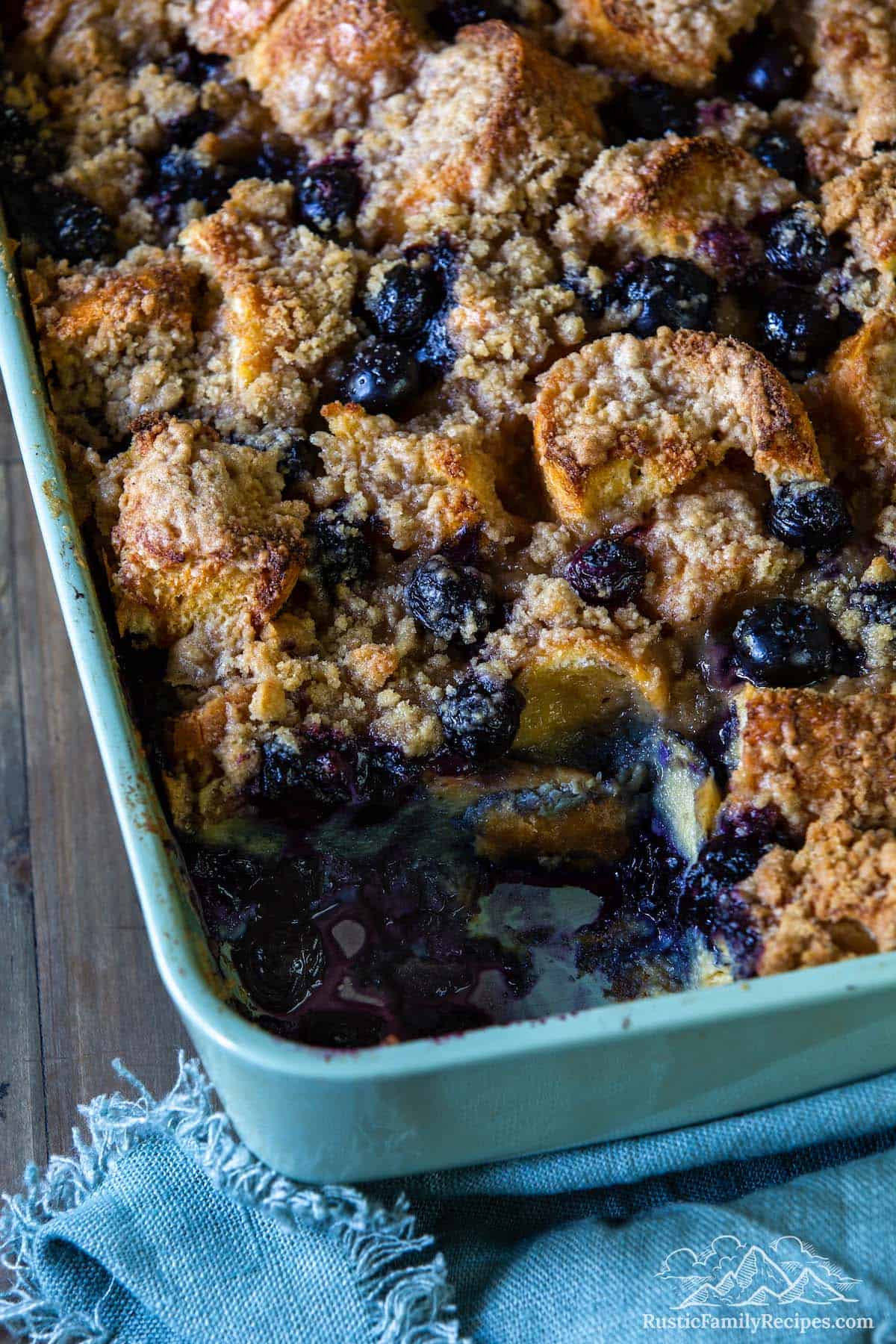 Blueberry french toast bake in a casserole dish with a slice taken out