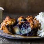 Slice of blueberry french toast bake with syrup and whipped cream