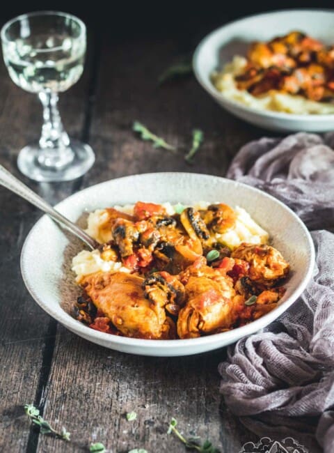 Two rustic bowls with chicken chasseur and mashed potatoes