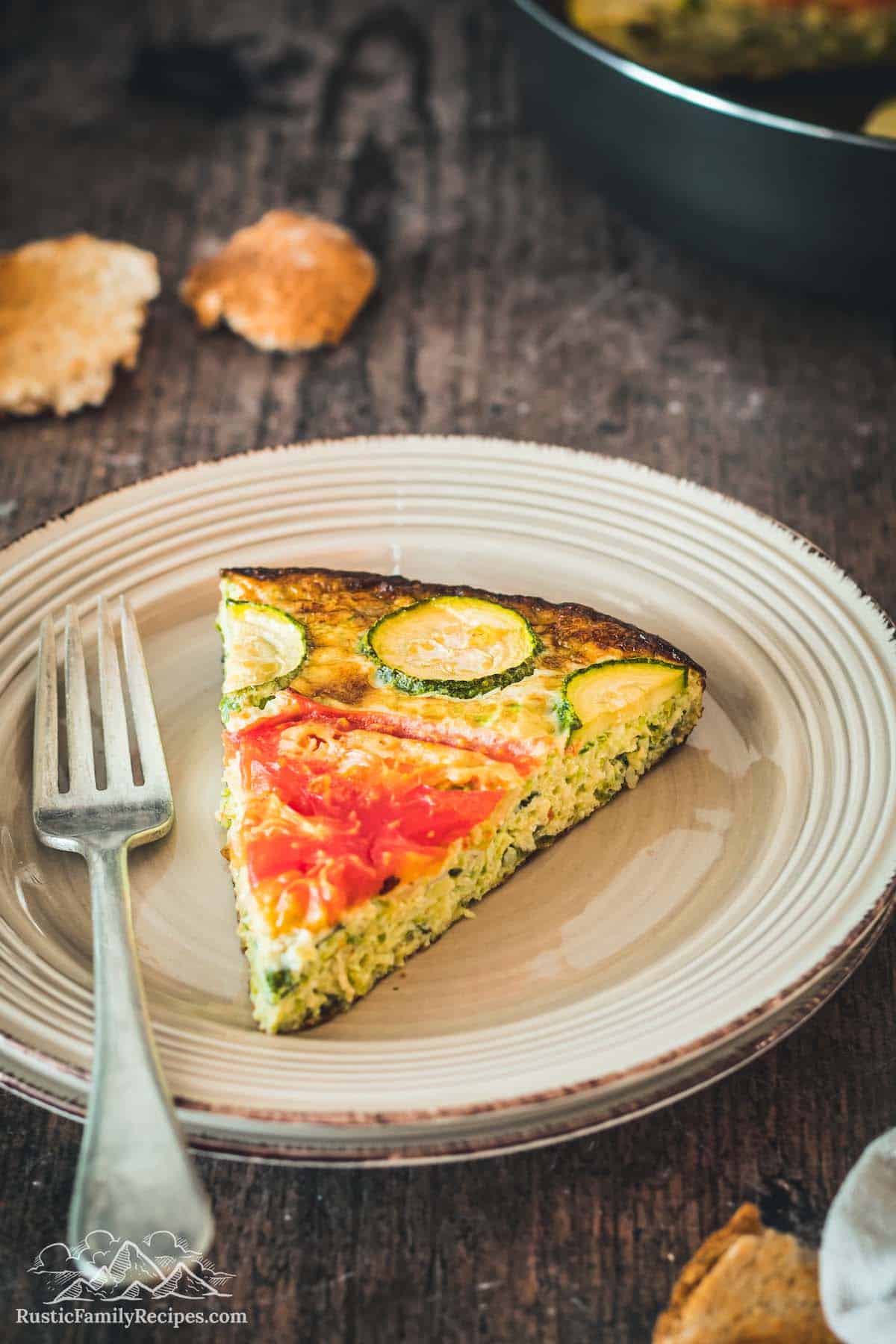 Slice of zucchini quiche on a white plate