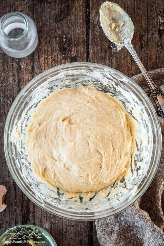 Sourdough Cinnamon Roll dough in glass bowl with spoon