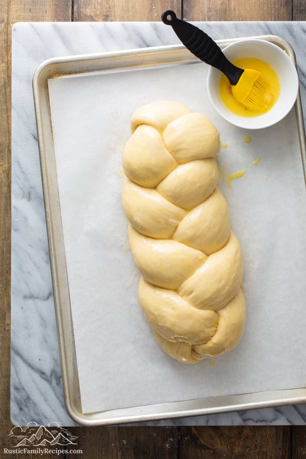 Overhead shot of Honey Vanilla Challah dough on parchment lined baking sheet