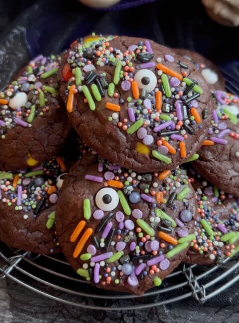 Pile of chocolate Monster cookies with Halloween sprinkles and candy eyes.