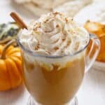 Homemade pumpkin spice latte in a glass mug with whipped cream and cinnamon