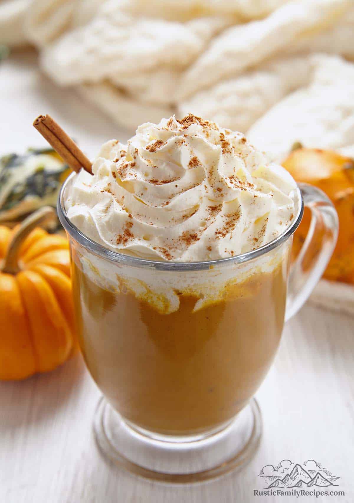 Homemade pumpkin spice latte in a glass mug with whipped cream and cinnamon
