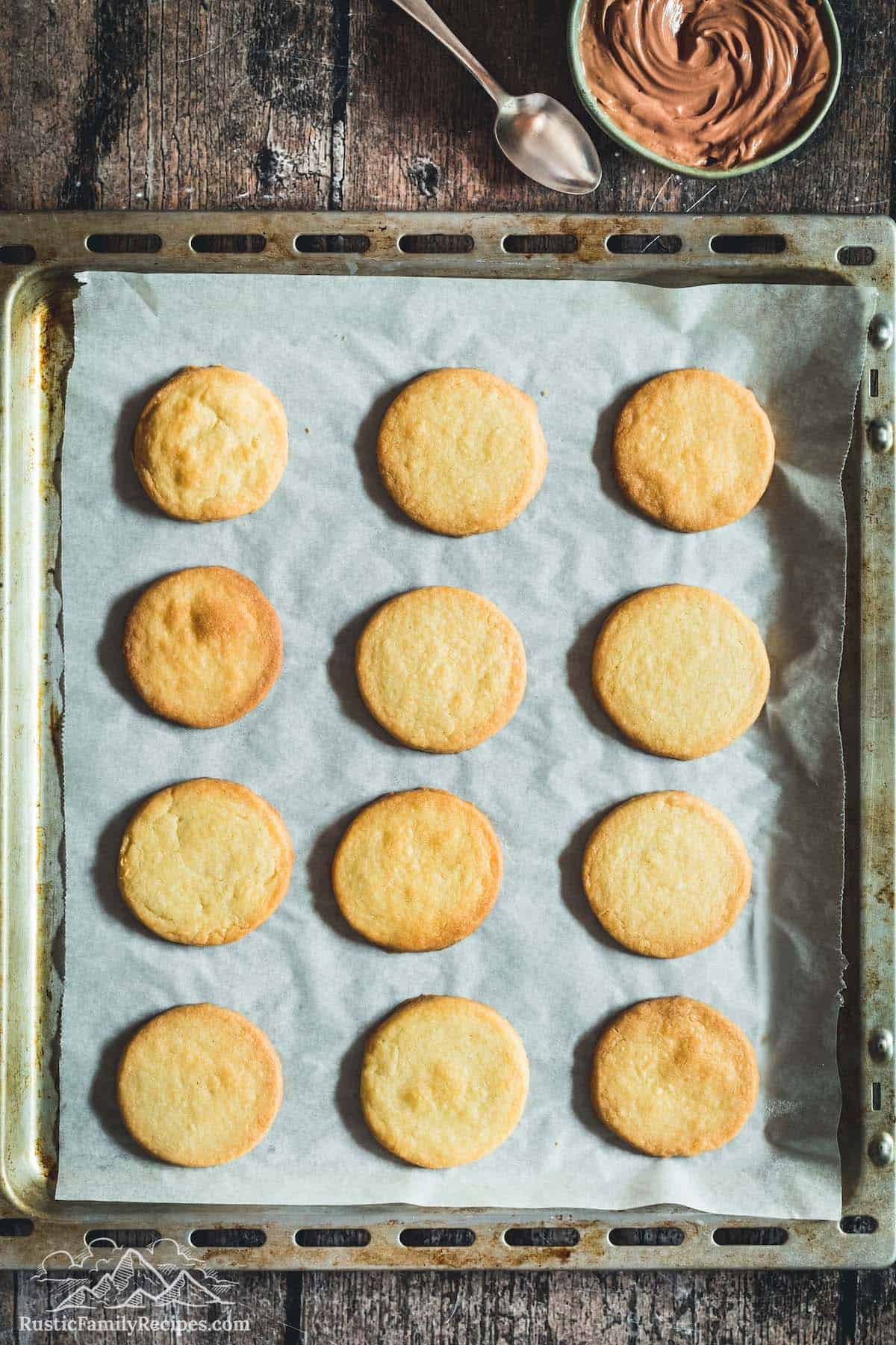 Vanilla cookies on baking sheet before filling