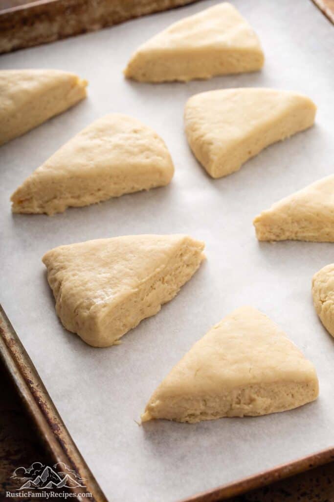 Unbaked scones arranged on parchment-lined baking sheet