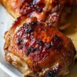 Baked chicken thighs on a white serving platter