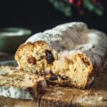 Homemade stollen loaf on a cutting board, sliced open to see the insides