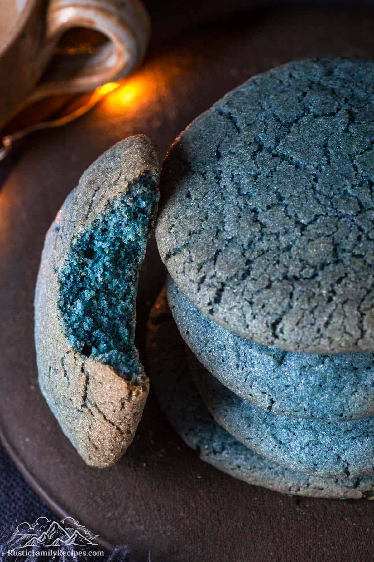 A stack of blue sugar cookies, one on its side with a bite taken out