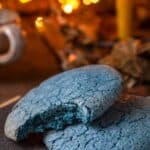 Two blue match sugar cookies, one with a bite taken out
