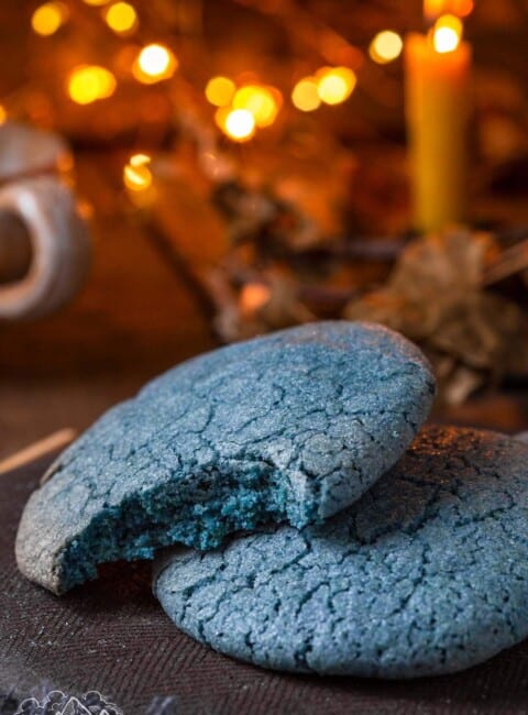 Two blue match sugar cookies, one with a bite taken out