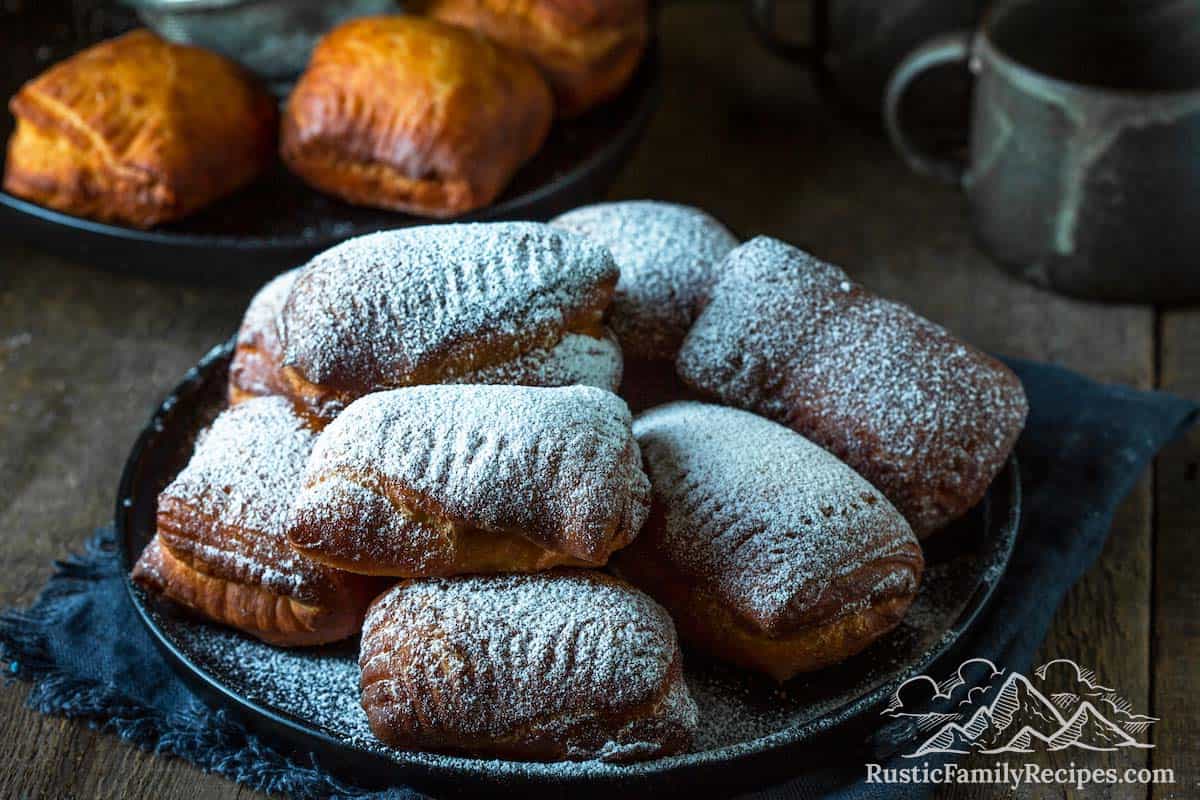 Pile of homemade beignets with powdered sugar