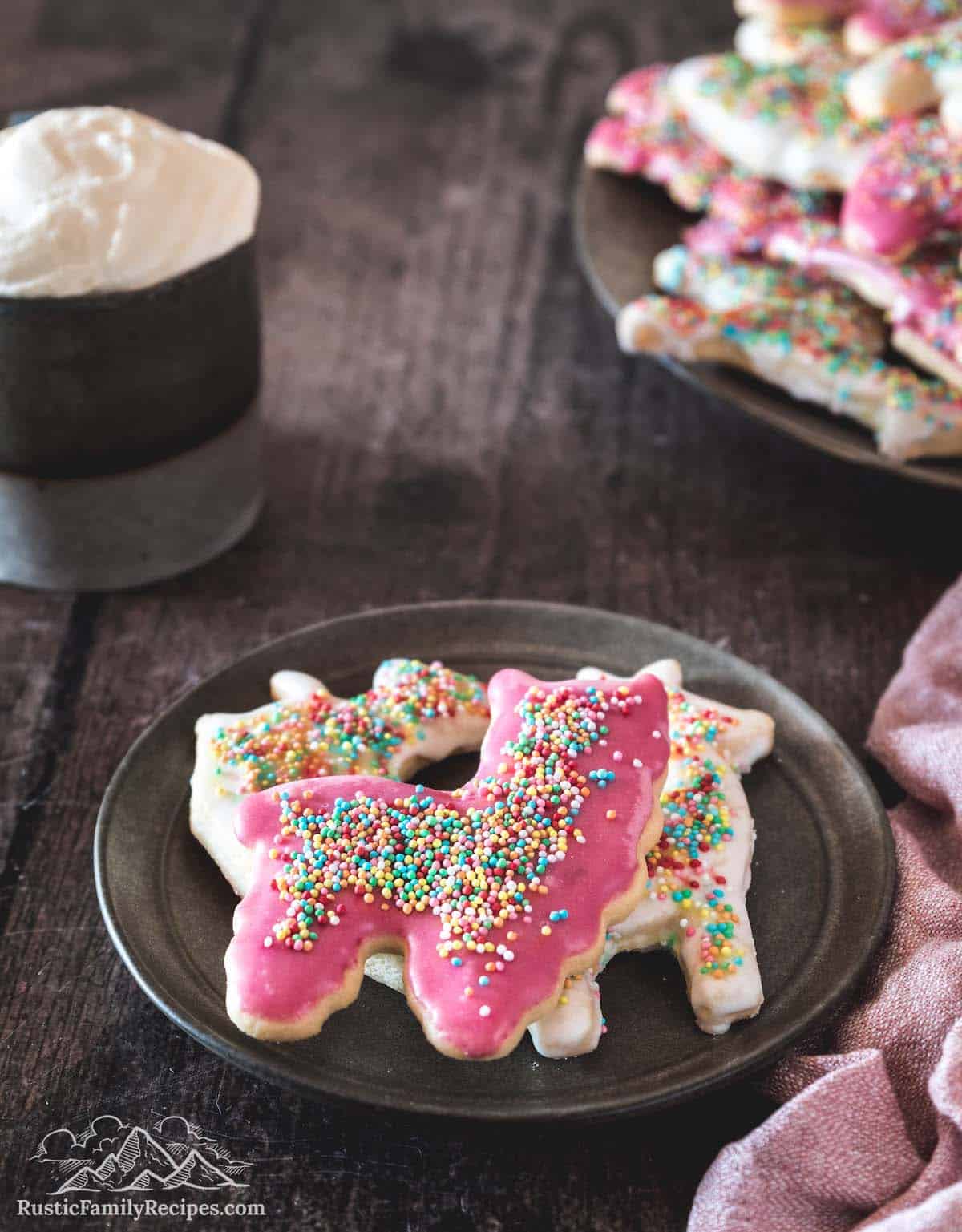 A plate with 3 frosted animal crackers on it