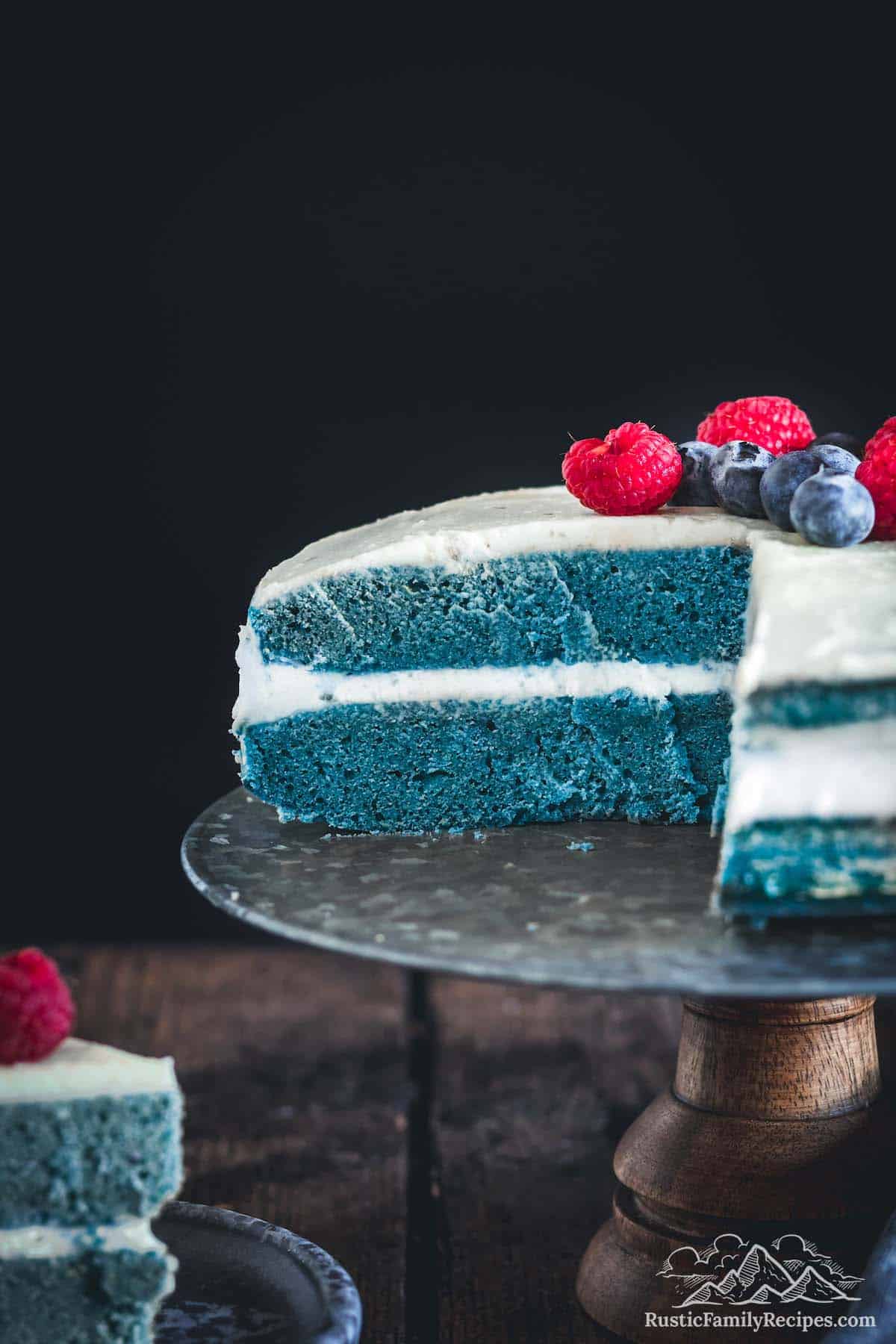 A blue matcha cake sliced open with two layers and frosting