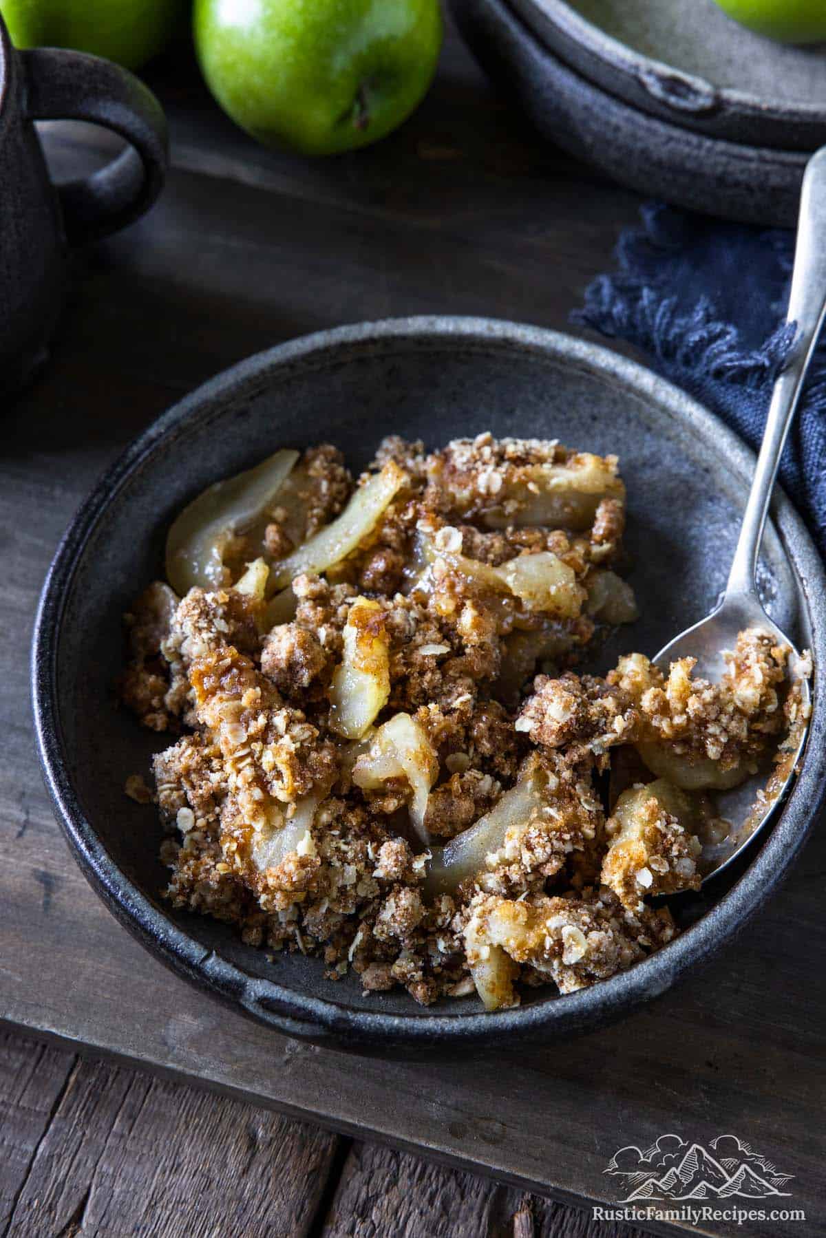Homemade apple crisp in a bowl with a spoon