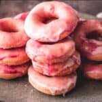A stack of pink donuts on a plate