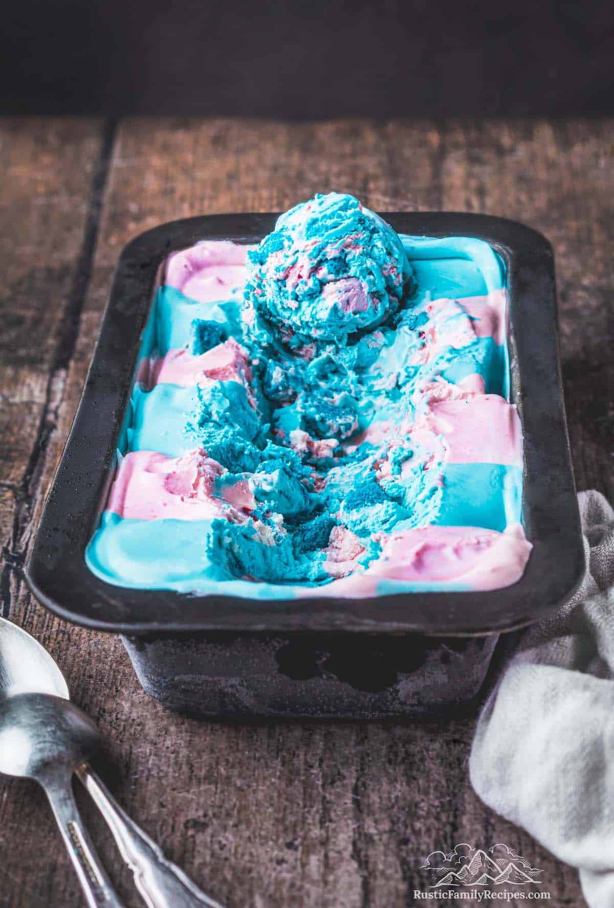 Cotton candy ice cream in a loaf pan with a scoop on top