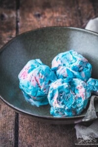 A rustic bowl with three scoops of cotton candy ice cream