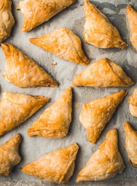 Golden greek feta pies on a baking sheet