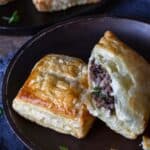 Ground venison meat pies on a black stoneware plate.