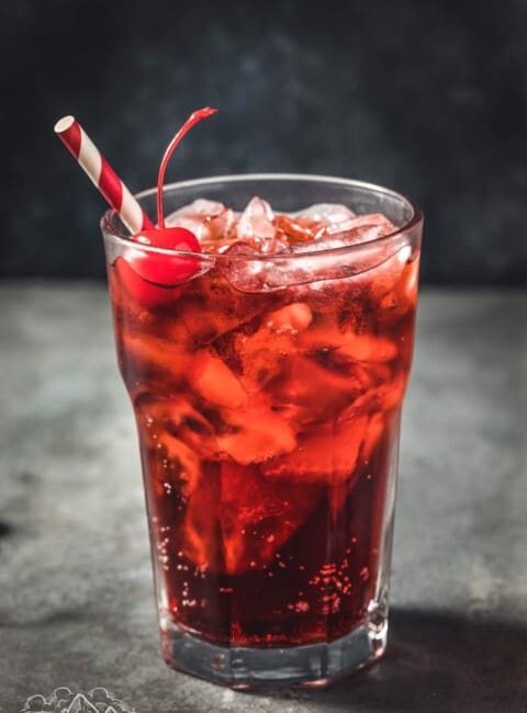 Roy rogers drink with a cherry, ice and striped straw
