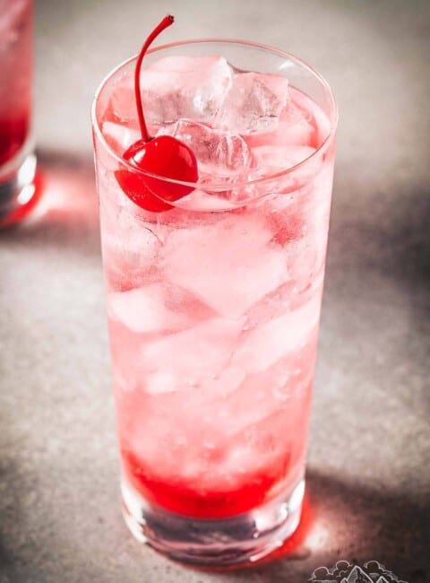 Shirley Temple drink in a tall glass with a cherry