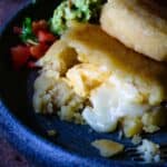 An arepa filled with eggs and cheese on a plate