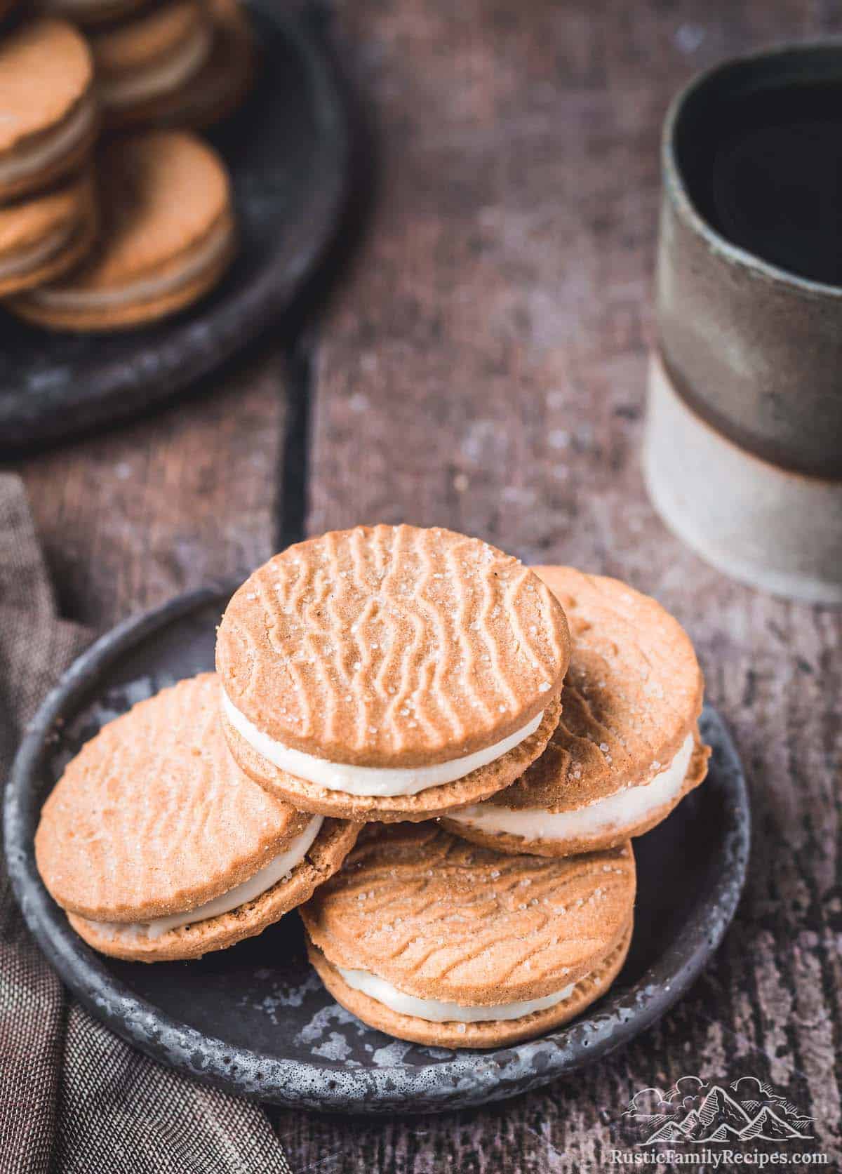 A small pile of Biscoff sandwich cookies on a grey stoneware plate.