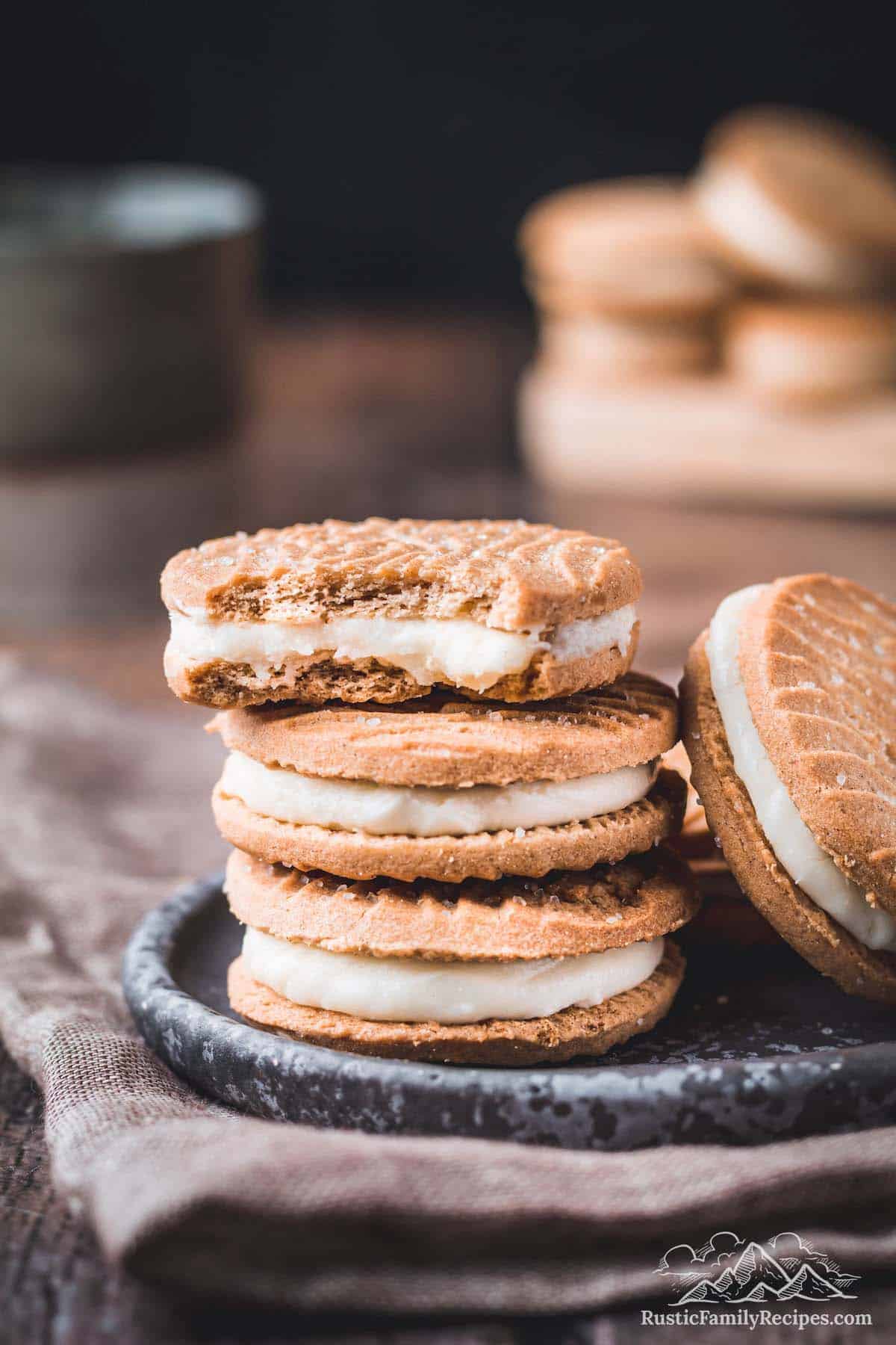 A stack of three Biscoff cookies with a bite missing from the top one.