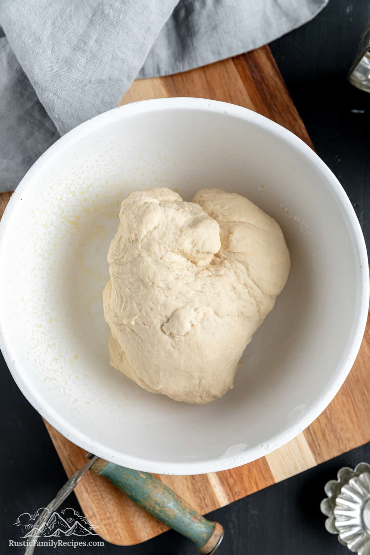 A white bowl with bolillos dough