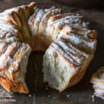 Fluffy Sugared Monkey Bread in a bundt shape with a slice missing.