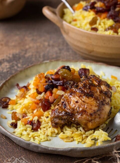 Saffron rice on a plate with chicken thighs
