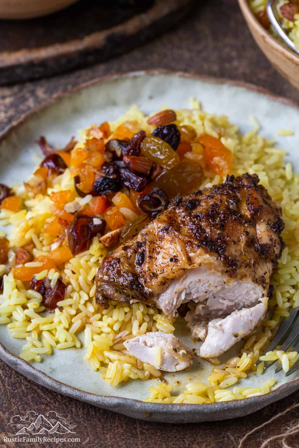 Cut open baked chicken thighs on a bed of saffron rice