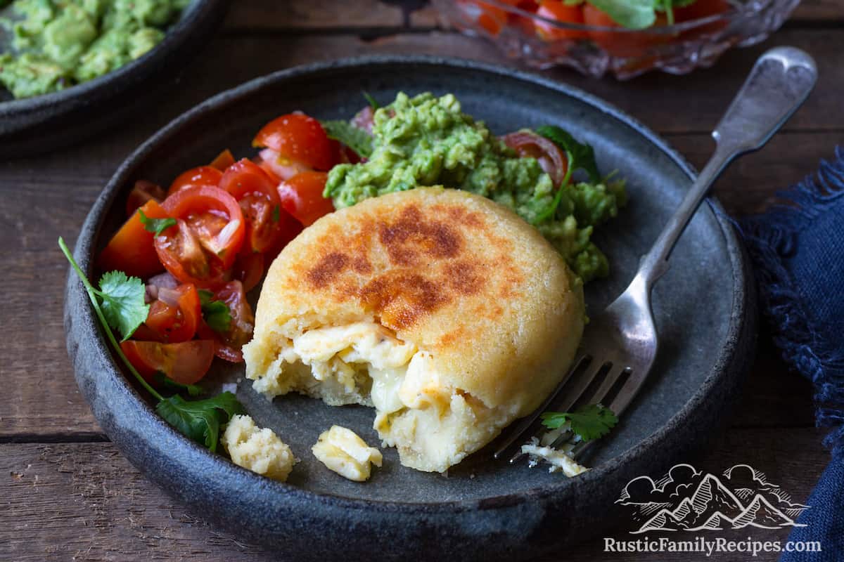 An arepa filled with eggs and cheese on a plate