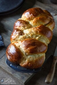 A loaf of braided challah in a bread pan