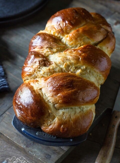 A loaf of braided challah in a bread pan