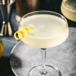 Bees knees cocktail with a lemon twist